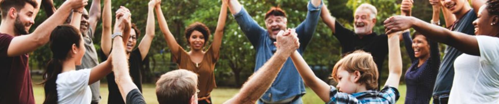 Decorative image showing a group of people holding hands in a circle in an outdoor space