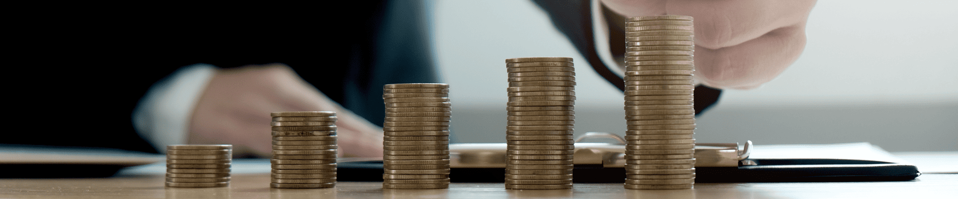 A man in a suit stacks coins.