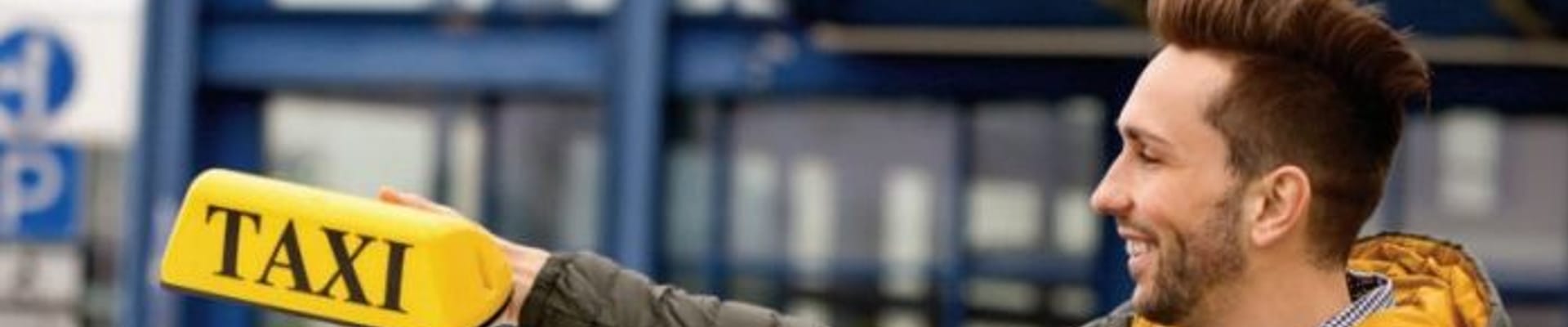 A man holding a taxi roof sign.