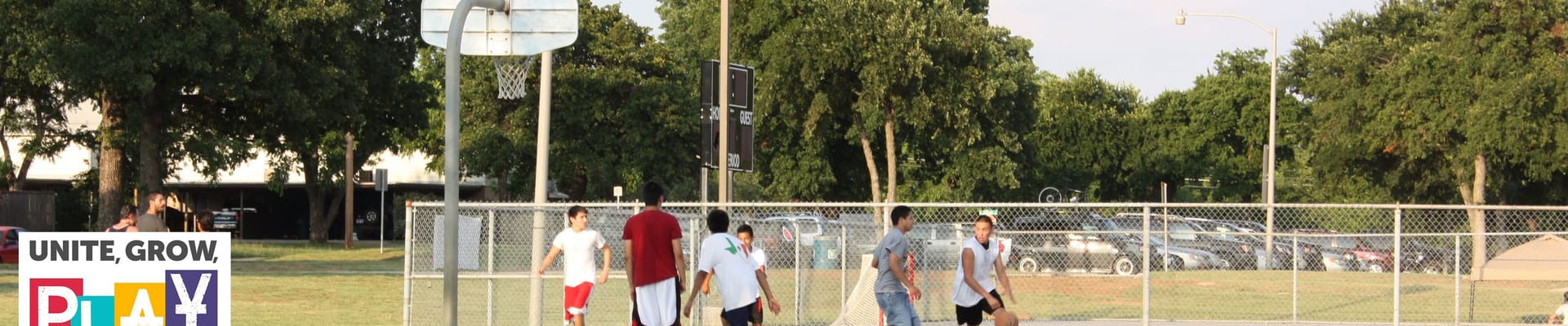 Photo of group of kids playing basketball on basketball court with parks and recreation logo on the bottom left corner
