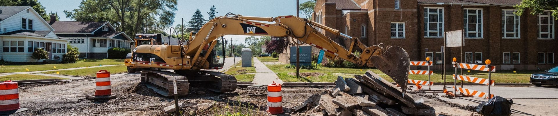 Road dug up to see dirt and orange cones