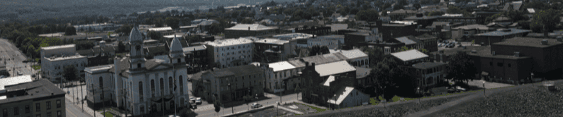 Aerial image overlooking the City of Lock Haven from the West Branch Susquehanna River. The Clinton County Courthouse and levee are shown in the foreground of the image.