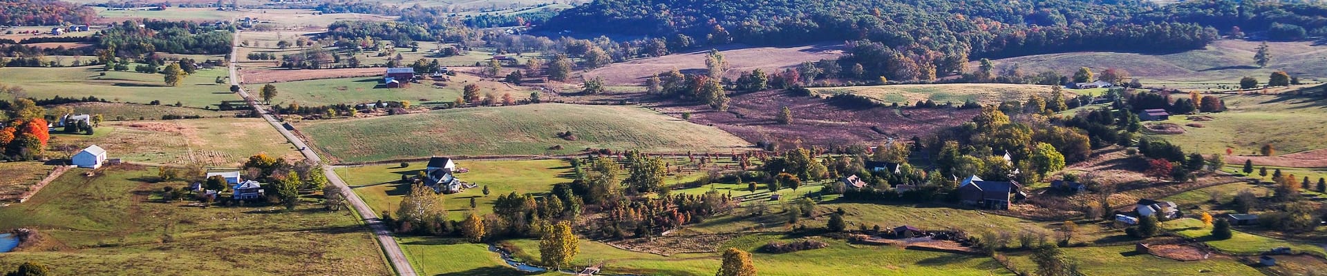 Rural Augusta County with mountains, green fields, and roadway. 