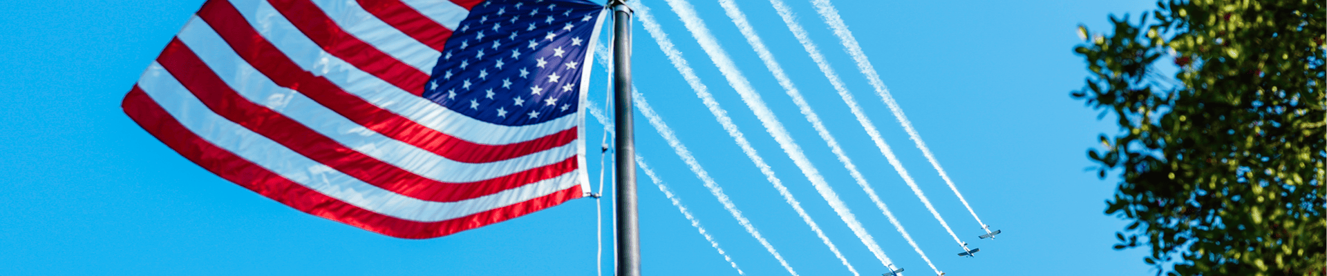 Planes from Falcon Field in sky behind American flag