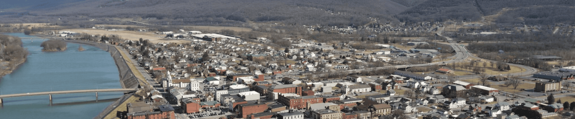 Drone picture of the Susquehanna River, two runners on the levee, and Water Street in Lock Haven