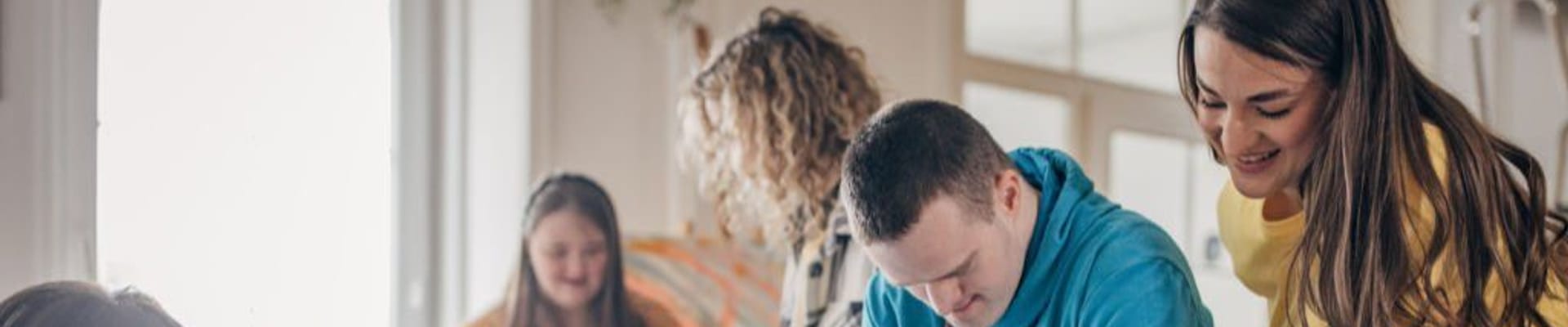 A group of disabled people doing an art project with help 