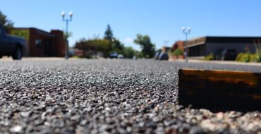 A zoomed in photo of asphalt with a raised lane marker.
