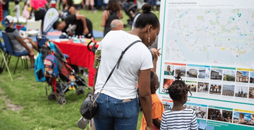 woman and children looking at consultation board