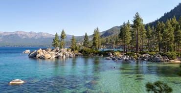 View of Lake Tahoe from Sand Harbor, featuring trees, mountains, rocks, and water
