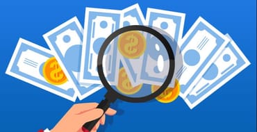 Magnifying glass over a pile of money
