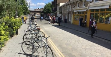 Image of quite street with cycle parking and small shops