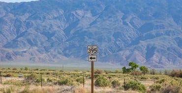 Landscape view of 395 Hwy sign, with mountains in the background