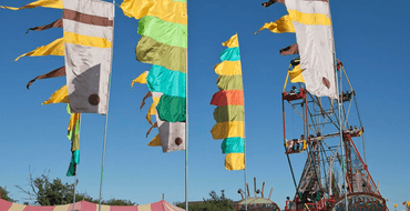 Image of colourfull flags and a ferris wheel