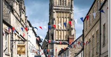 Image of high street with The Parish Church of St John Baptist in the background 