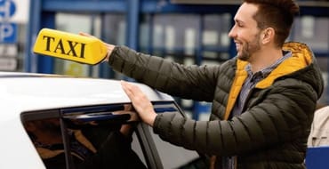 A man holding a taxi roof sign