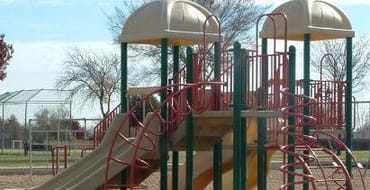 children's playground with slides and climbing features located in a park