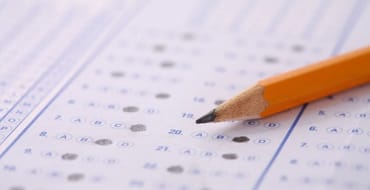 Photo of a paper multiple choice form and an orange pencil