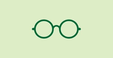 Simple green icon of a pair of round glasses on a light green background. The glasses have circular lenses connected by a small bridge and thin green frames. 