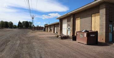 City-owned redevelopment site along North 4th Street in Laramie, showing existing utility buildings, gravel areas, and service facilities.