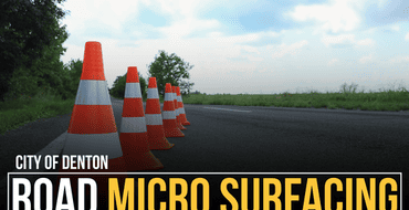 orange cones on road with green trees behind them and text says "Road Micro Surfacing"