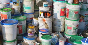 Paint cans and other hazardous waster materials piled up