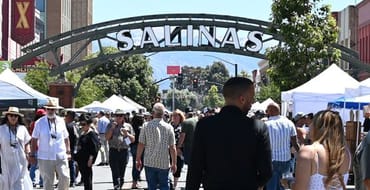 People walking, talking and smiling downtown near the Salinas arch during the food and wine festival
