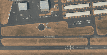 Birds eye view from above looking down on the runway, taxiway, windsock, aprons and hangars at Pearson Field.