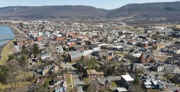 aerial image showing buildings in the city as well as the river and mountains in the distance