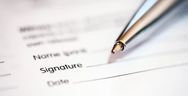 Photo of a paper form and chrome-coloured pen. 