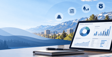 Tablet displaying an interactive financial dashboard with charts and graphs, overlooking a northern Nevada city and mountain landscape with icons for roads, libraries, parks and public safety