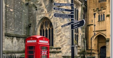 Image of a telephone box and a sign post outside The Parish Church of St John Baptist