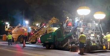 County employees working on a roadway at night.