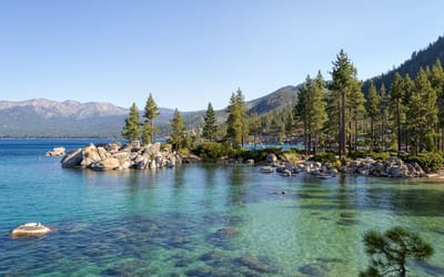 View of Lake Tahoe from Sand Harbor, featuring trees, mountains, rocks, and water