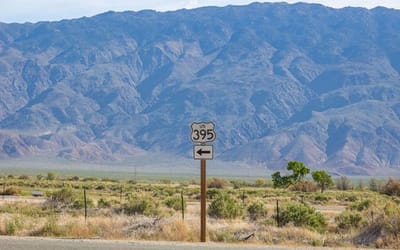 Landscape view of 395 Hwy sign, with mountains in the background