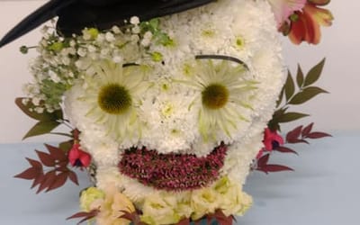 Flower display of an owl with a hat on his head