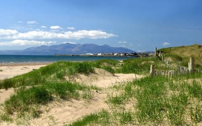 The photograph shows the dunes in Stevenson, with the Isle of Arran in the background