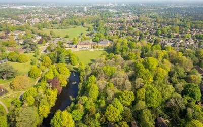 Aerial view over South Hill park, lake and building.