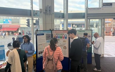 Members of the public discussing with project team members in front of display boards exhibiting the work.