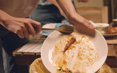 Image of food scraps being put in the bin 