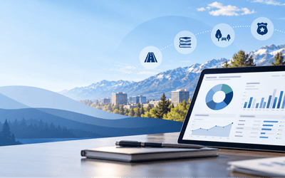 Tablet displaying an interactive financial dashboard with charts and graphs, overlooking a northern Nevada city and mountain landscape with icons for roads, libraries, parks and public safety