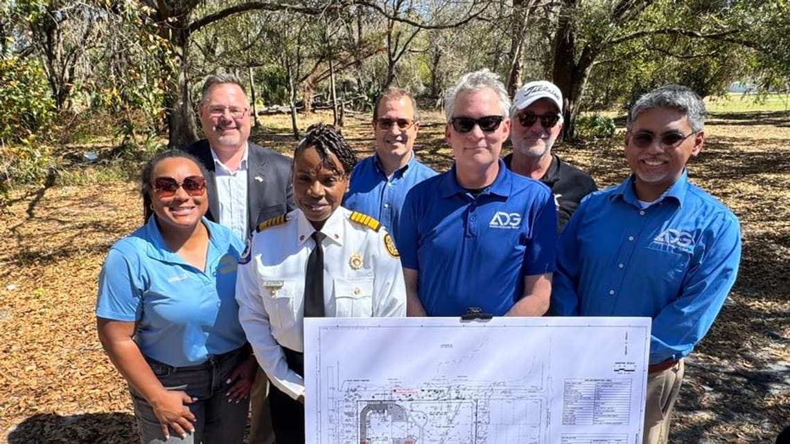 Tampa Fire Chief Barbara Tripp poses for a group shot with the design and construction representatives for the Fire Station 24 construction project.