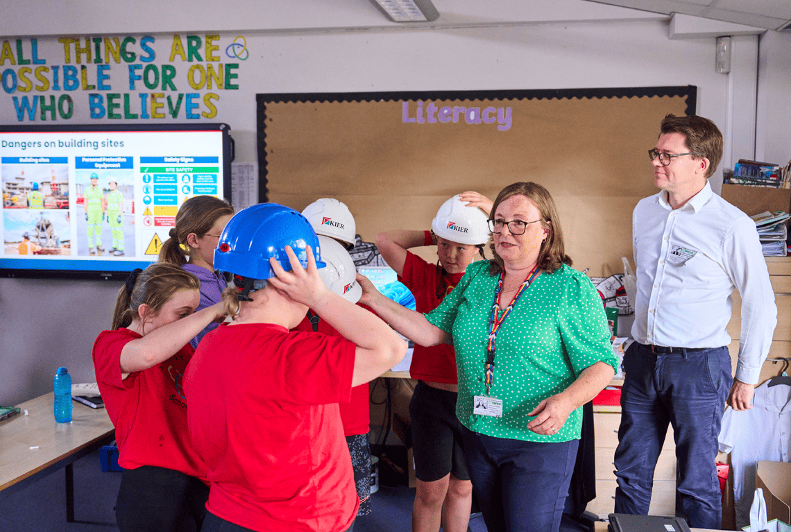 A photo of primary school children trying on construction helmets
