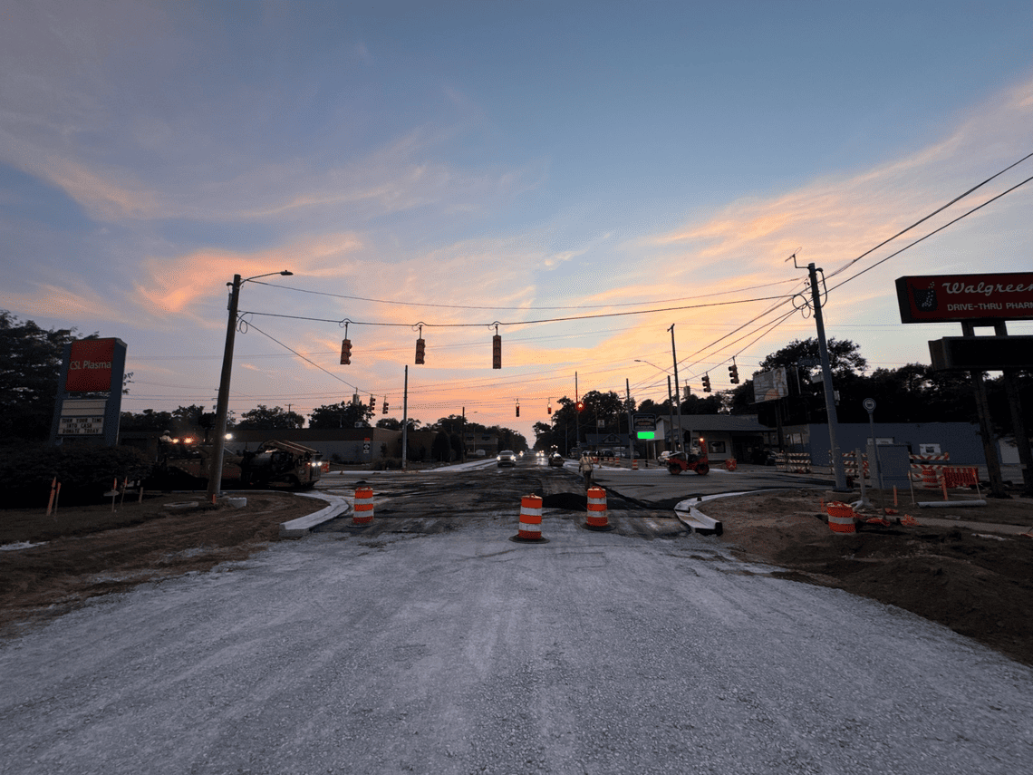 Crews pave the Getty Street intersection, with construction equipment, traffic barrels and newly poured concrete curbs visible along the roadway.