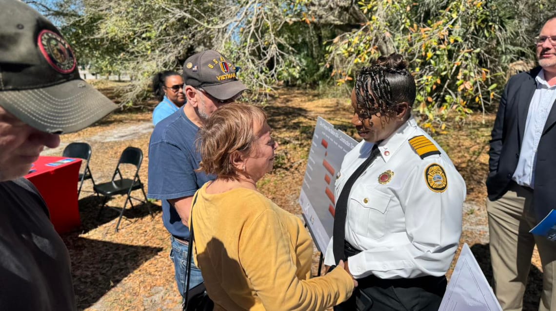 Photo of Tampa Fire Chief Barbara Tripp greeting a north Tampa woman