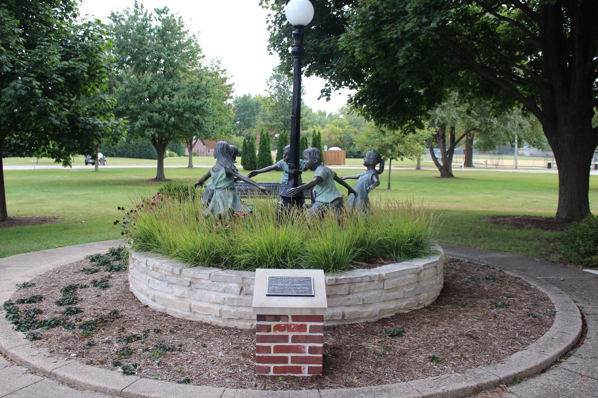 Image of statue in One Normal Plaza of children circling a pole