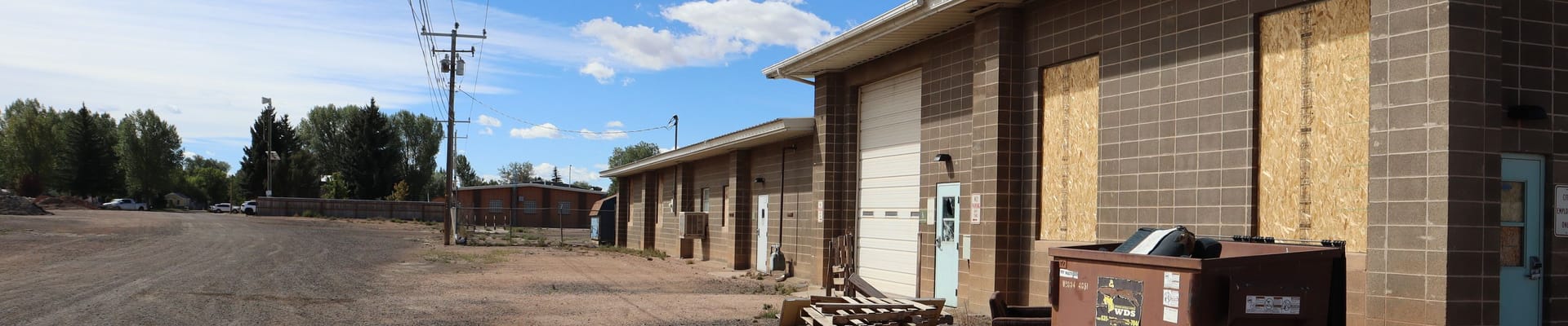 City-owned redevelopment site along North 4th Street in Laramie, showing existing utility buildings, gravel areas, and service facilities.