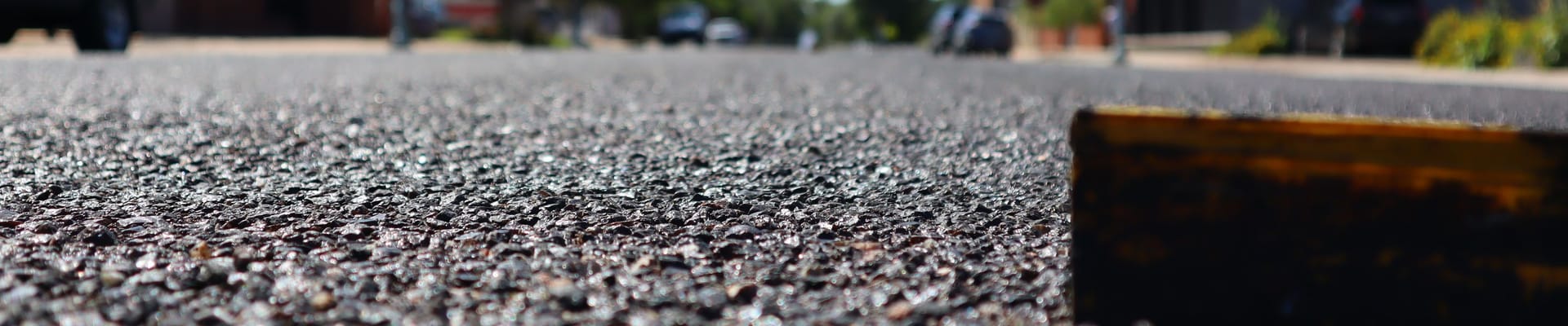 A close up of asphalt and a raised lane marker.