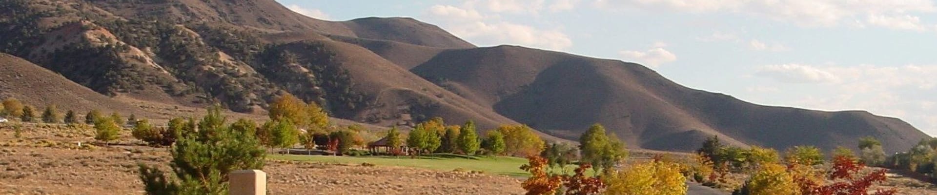 Hidden Valley Regional Park, featuring trees, park signage, road access, and mountains