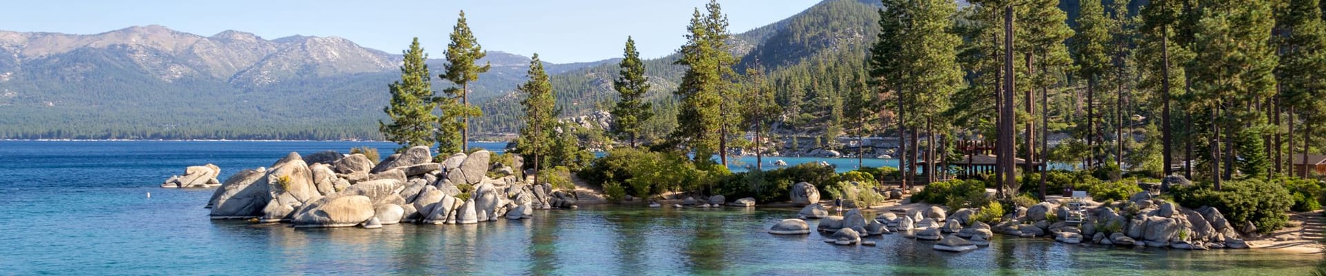 View of Lake Tahoe from Sand Harbor, featuring mountains, rocks, trees, and water