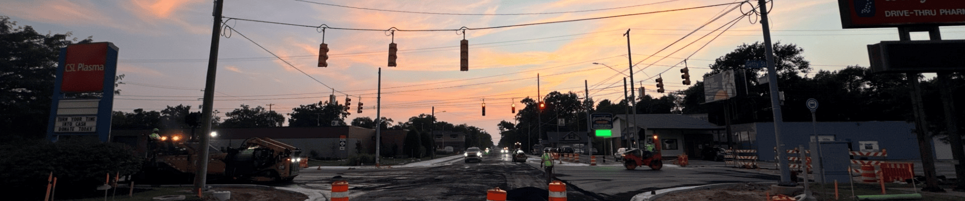 Crews pave the Getty Street intersection, with construction equipment, traffic barrels and newly poured concrete curbs visible along the roadway.